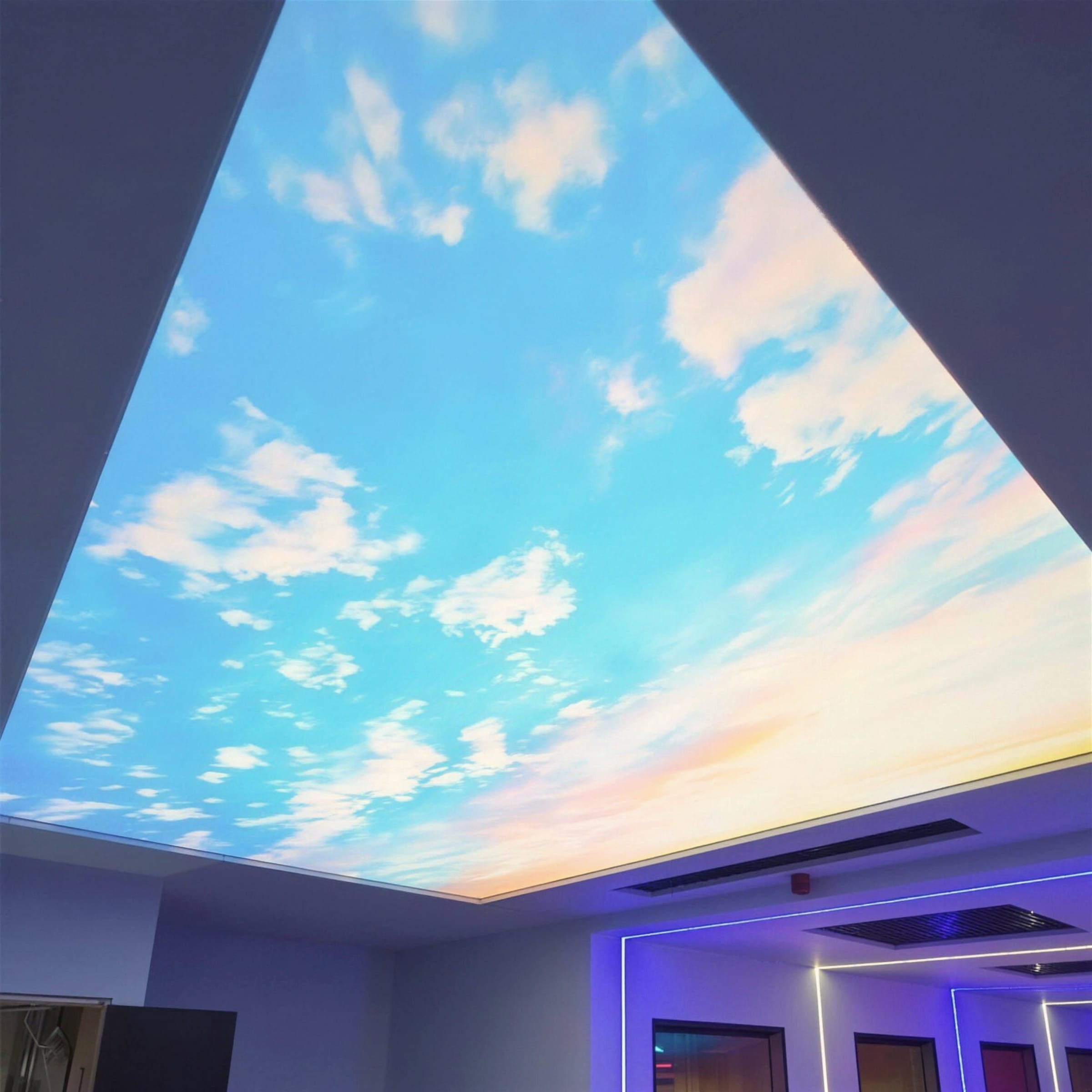 Hero-grade frame: crisp blue-sky backlit ceiling with a sunset gradient edge, echoed by cool blue LED coves in the rooms beyond.