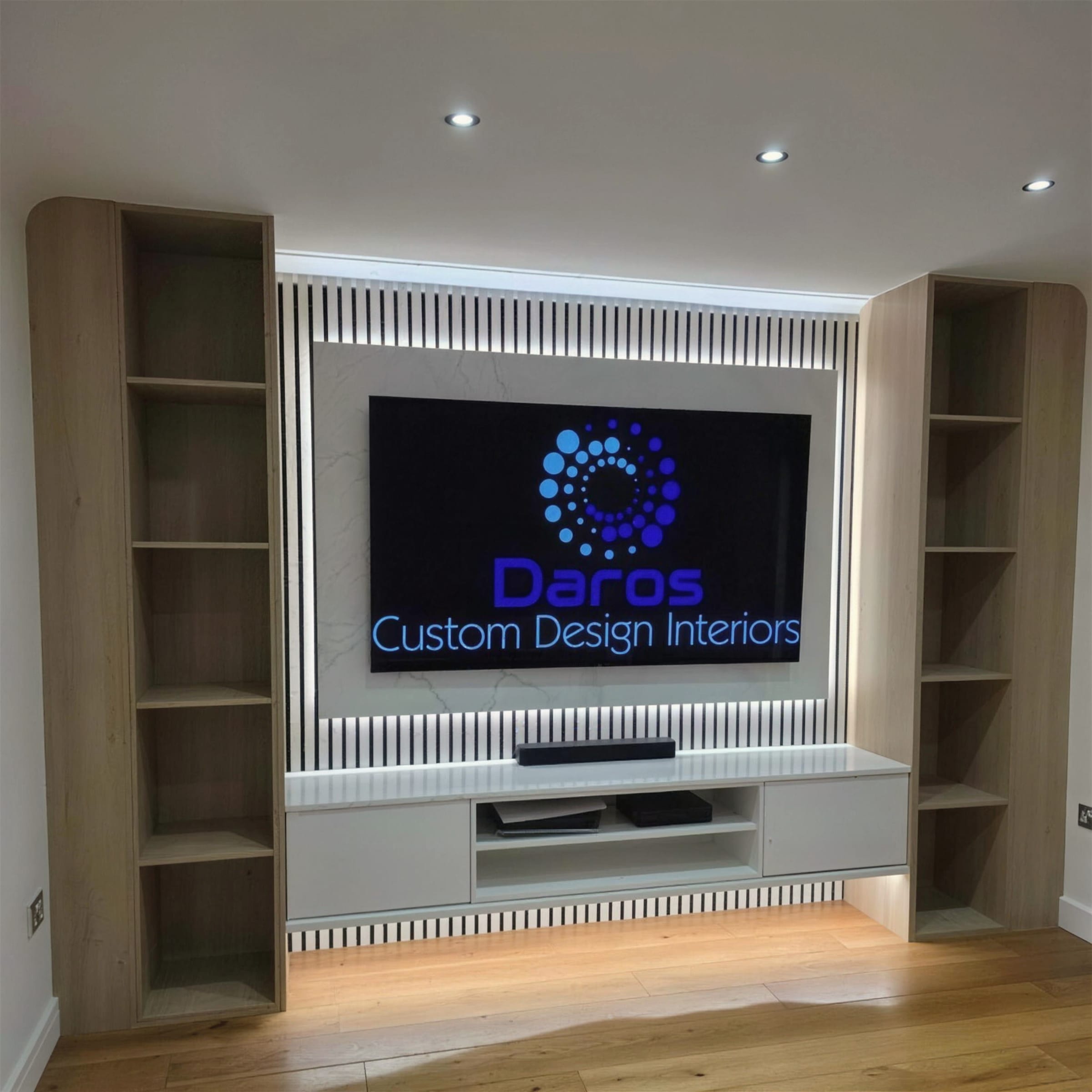 Symmetrical light-oak shelving media wall with an LED backlit black-and-white slat panel and recessed TV.