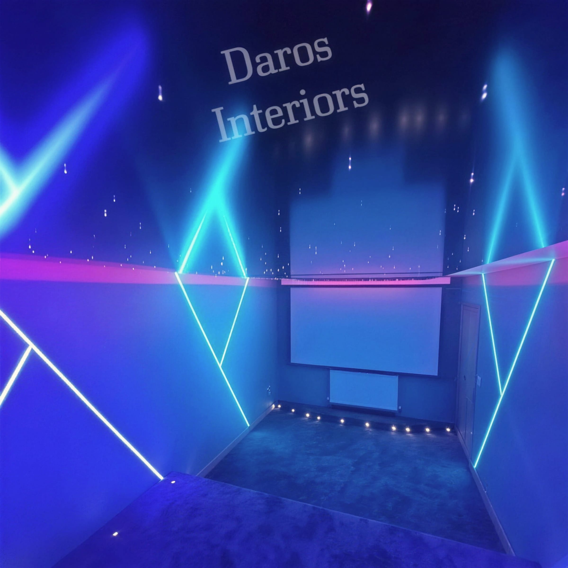 Home cinema bathed in blue light with a star-field ceiling, diagonal LED beams, projector screen and radiator on the far wall, watermarked Daros Interiors.