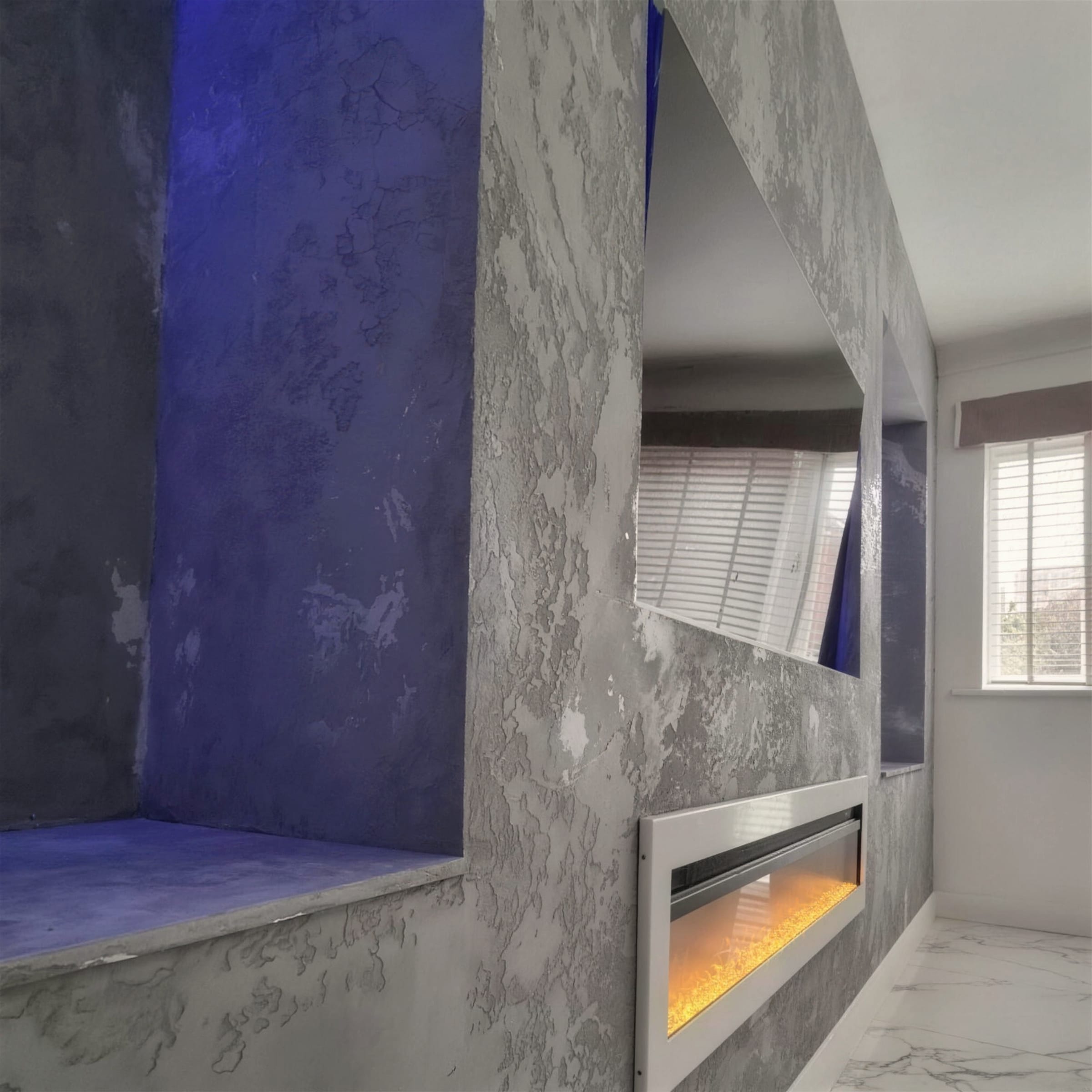 Rustic grey concrete-effect plaster media wall with blue LED-lit display niches and a recessed flame-effect fire over marble-look flooring.