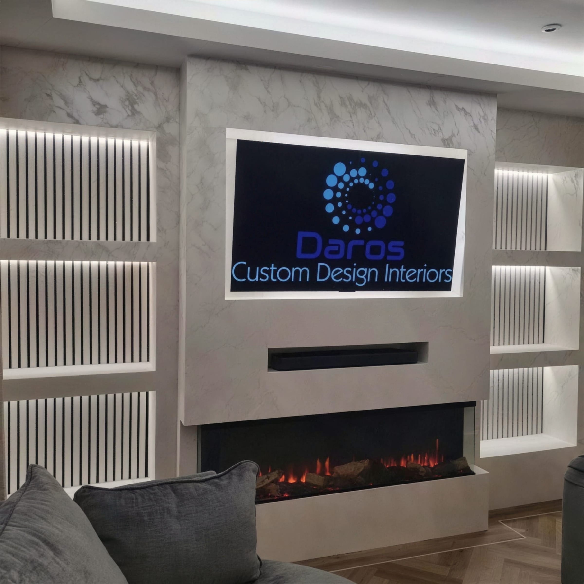 Polished pearl plaster media wall with vertical LED-lit slat niches, lit inset fireplace and the Daros brand logo on screen.